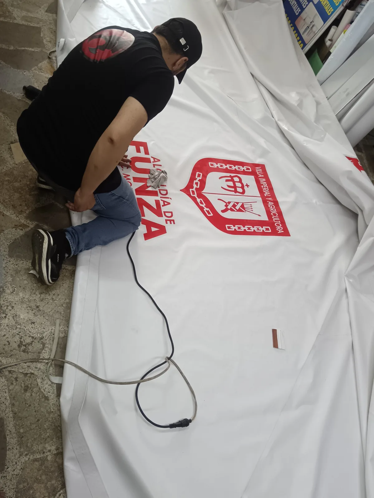 Impresión de logo institucional en lona de gran formato durante el proceso de producción